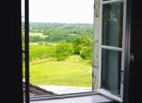 Views onto the garden through an open window from the bedroom