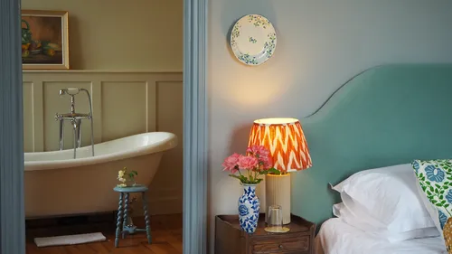 Bedroom with bed and views of the bathtub through the door