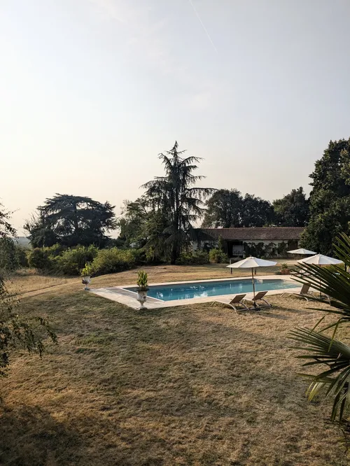 Pool and gardens with sun loungers and umbrellars