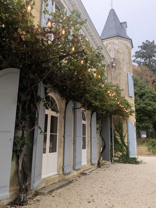 Chateau front terrace and shutters with festoon lighting in the evening