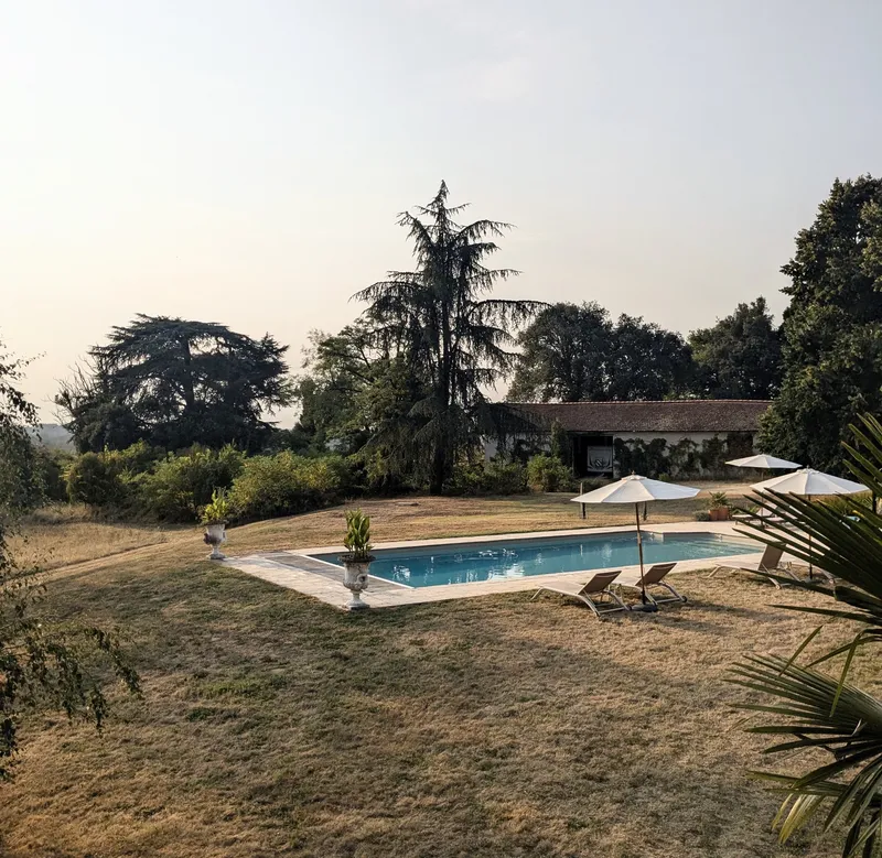 Pool and gardens with deckchairs and sun umbrellas